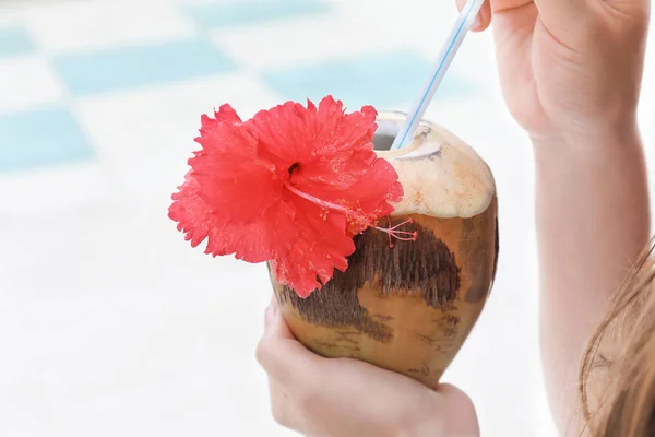 Ung kvinna med färsk kokos cocktail på resort, närbild — Stockfoto