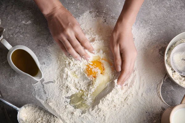 Женщина-повар делает тесто на кухонном столе — стоковое фото
