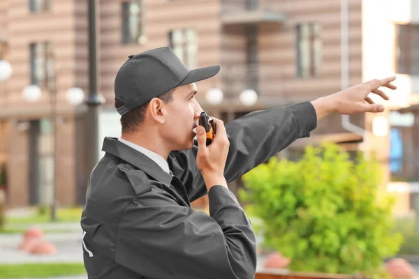Protetor de segurança masculino com rádio portátil, ao ar livre — Fotografia de Stock