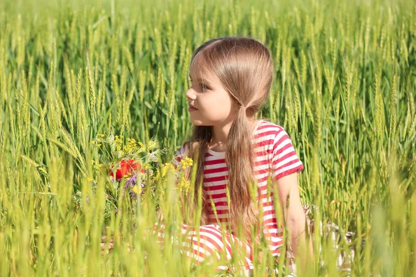 그린 필드에 야생화의 꽃다발과 어린 소녀 — 스톡 사진