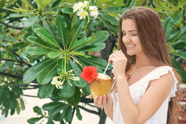 Mujer joven con cóctel de coco fresco en el resort — Foto de Stock