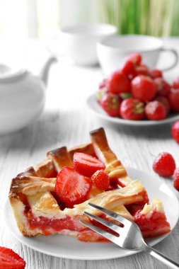 Lezzetli bir parça ahşap masa üzerinde çilekli kek ile plaka