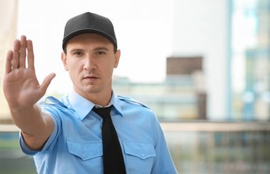 Erkek güvenlik görevlisi dur jest, açık havada gösterilen