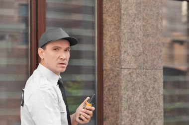 Erkek güvenlik görevlisi ile taşınabilir radyo, açık havada