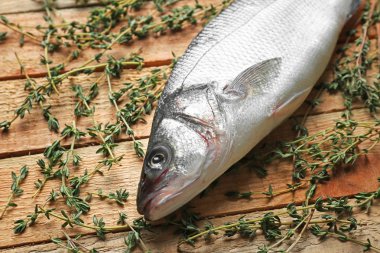 Ahşap zemin üzerine kekik ile taze balık