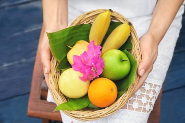 Hasır kase taze meyve ile açık havada tutan genç kadın