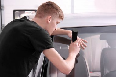 Tamir atölyesindeki arabanın ön camında çatlak var.