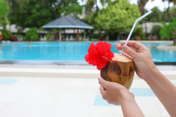 Ung kvinna med färsk kokos cocktail på resort — Stockfoto