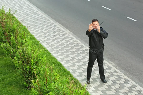 Male security guard with portable radio, outdoors — Stock Photo, Image