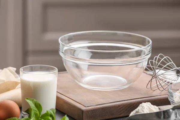 Tigela de vidro vazia e ingredientes para massa na mesa da cozinha — Fotografia de Stock