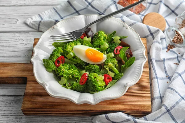 Dish with broccoli salad on wooden board — Stock Photo, Image