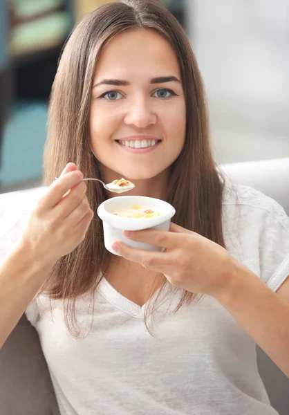 Genç kadın evde yoğurt yemek