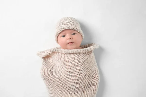 Bebê recém-nascido bonito em casulo de malha no fundo branco — Fotografia de Stock