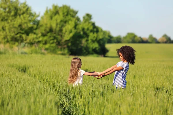 Счастливые маленькие девочки в зеленом поле — стоковое фото