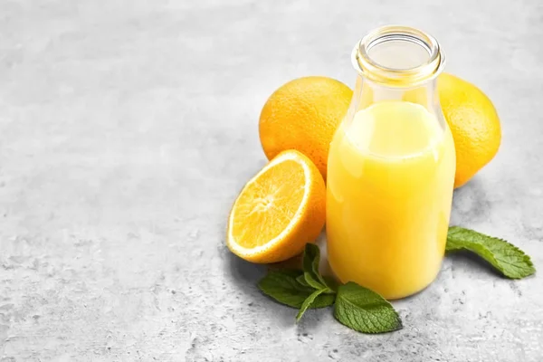 Бутылка свежего апельсинового сока на столе — стоковое фото
