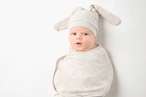 Bebê recém-nascido bonito em casulo e chapéu engraçado no fundo branco — Fotografia de Stock