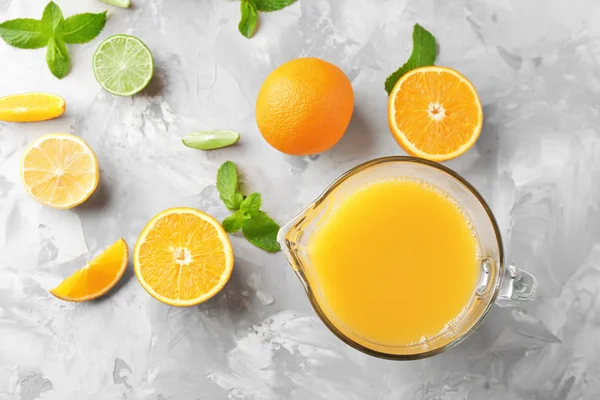 Jarra con zumo de naranja fresco en la mesa —  Fotos de Stock