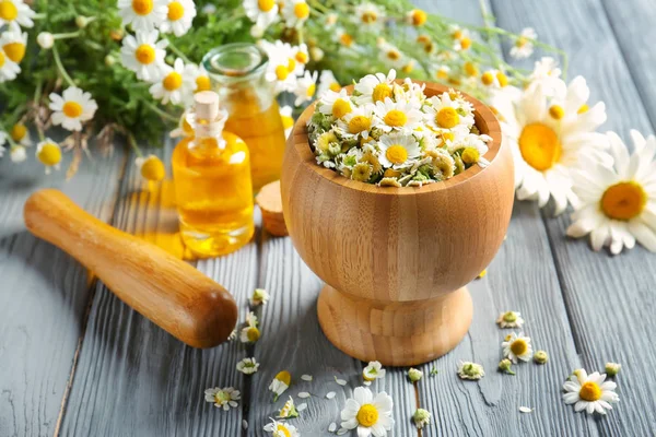 Essential oil and chamomile flowers — Stock Photo, Image