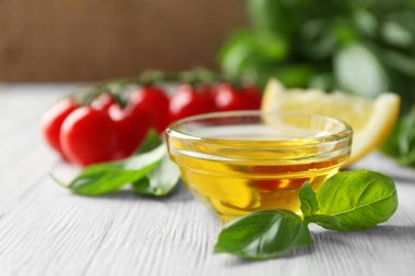 Fesleğen yağı, yeşil yaprakları ve domates ile kase