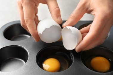 Çörek teneke, closeup içine yumurta çatlama kadın