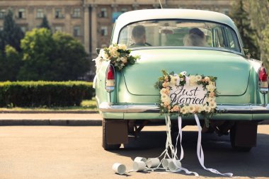 Düğün çifti ile dekore edilmiş arabada sadece evli plaka ve açık havada kutular