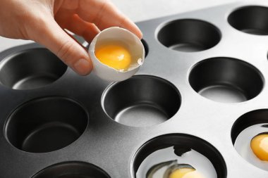 Çörek teneke, closeup içine yumurta çatlama kadın