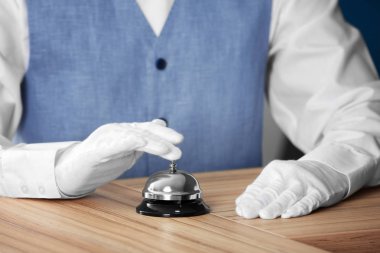 Adam ahşap masa üzerinde bir hizmet zil