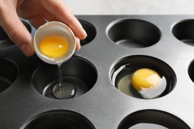 Çörek teneke, closeup içine yumurta çatlama kadın