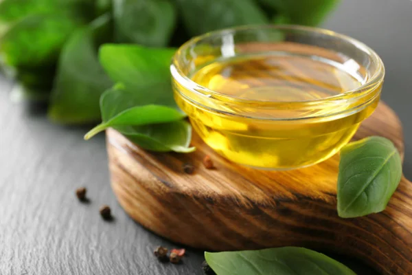 Bowl with basil oil and green  leaves — Stock Photo, Image