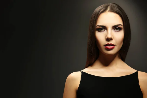 Портрет красивой молодой женщины модели с ярким макияжем на темном фоне — стоковое фото