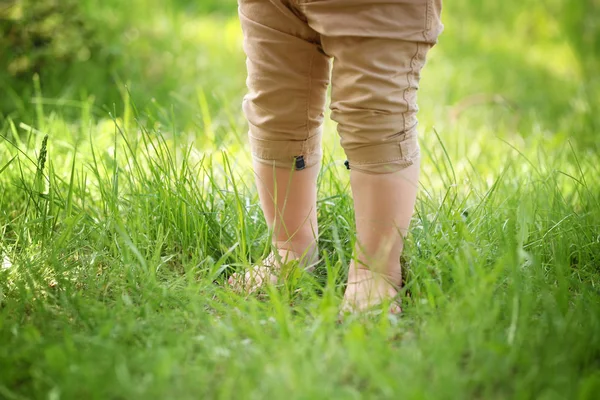 Little child walking on green grass in park — Stock Photo, Image