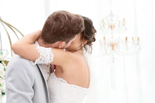 Gelukkige mooie paar kussen op trouwdag, binnenshuis — Stockfoto