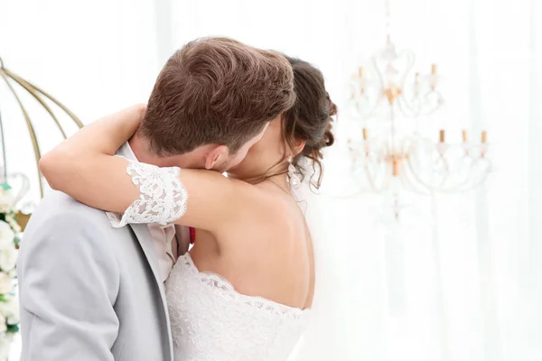 Feliz lindo casal beijando no dia do casamento, dentro de casa — Fotografia de Stock