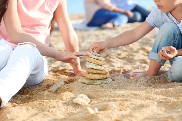 Roztomilé děti si hrají s kameny na pláži moře — Stock fotografie
