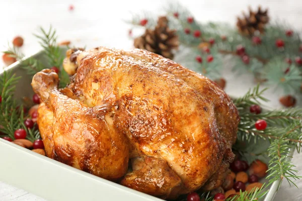 Bandeja para hornear con pavo asado, ramas de abeto y nueces en la mesa — Foto de Stock