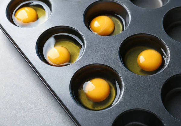 Muffin tin with raw eggs — Stock Photo, Image