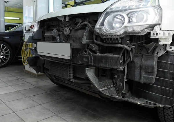 Carro danificado na oficina de reparação, close-up — Fotografia de Stock