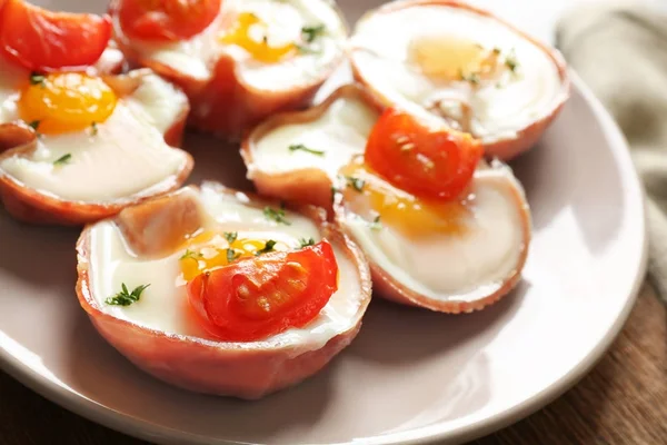 Uova saporite con pomodori in prosciutto su piatto — Foto Stock