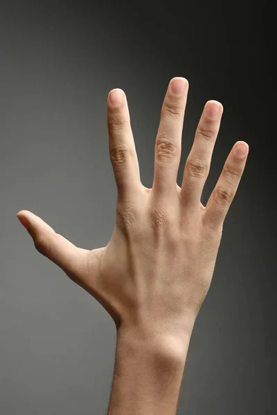 Männliche Hand auf grauem Hintergrund — Stockfoto