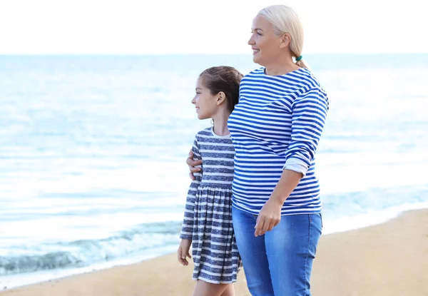 Linda chica con la abuela en la playa del mar —  Fotos de Stock