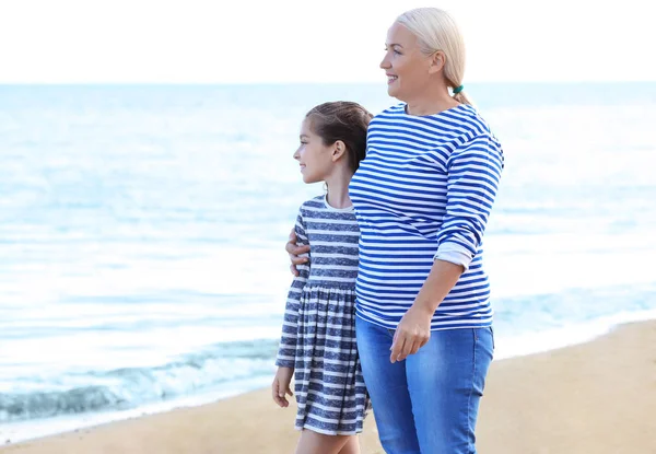 Fille mignonne avec grand-mère sur la plage de la mer — Photo