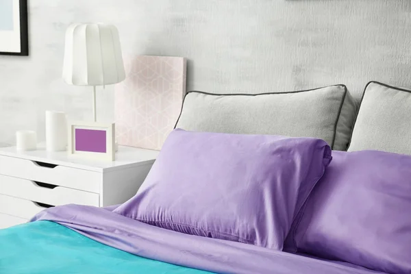 Acento lila en el interior moderno. Cómoda cama con almohadas en la habitación —  Fotos de Stock