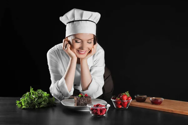 Chef femenino con postre sobre fondo oscuro — Foto de Stock