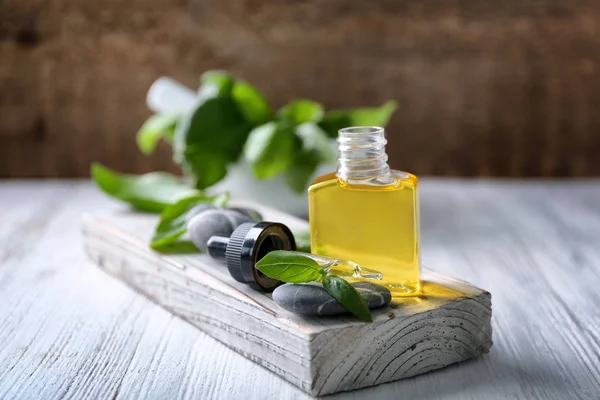 Garrafa com óleo de manjericão e folhas verdes — Fotografia de Stock