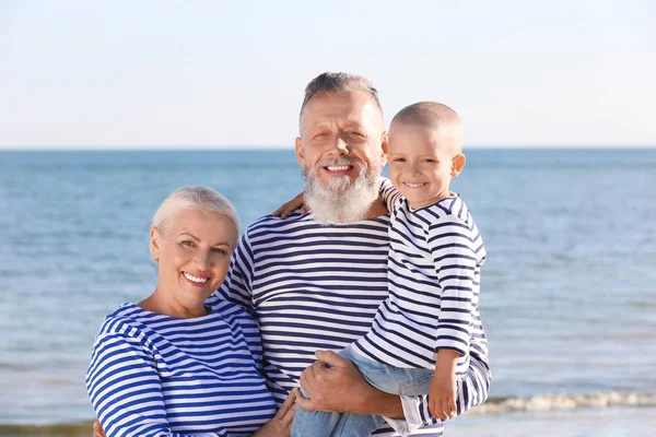 Милий хлопчик з бабусею і дідусем на морському пляжі — стокове фото