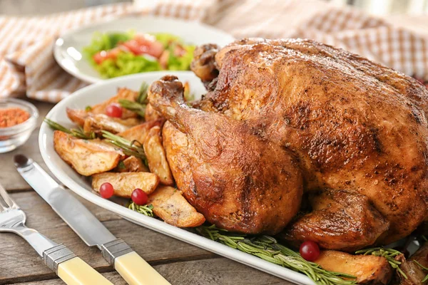 Tasty roasted turkey with potatoes on plate — Stock Photo, Image