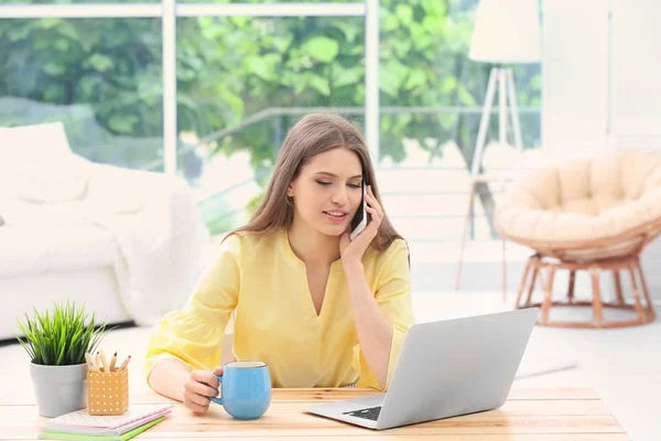 Jeune femme travaillant à la maison — Photo