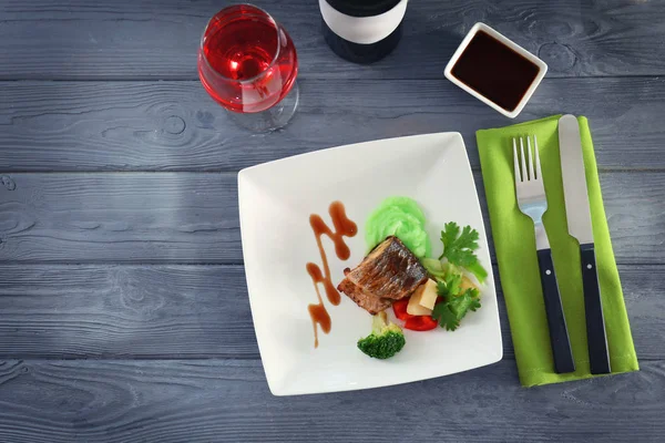 Assiette avec de délicieux poissons, sauce et légumes — Photo