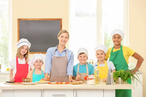 Grupo de crianças e professor na cozinha durante as aulas de culinária — Fotografia de Stock