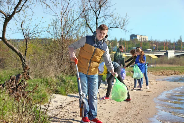Jovens limpando área de praia. Conceito de voluntariado — Fotografia de Stock